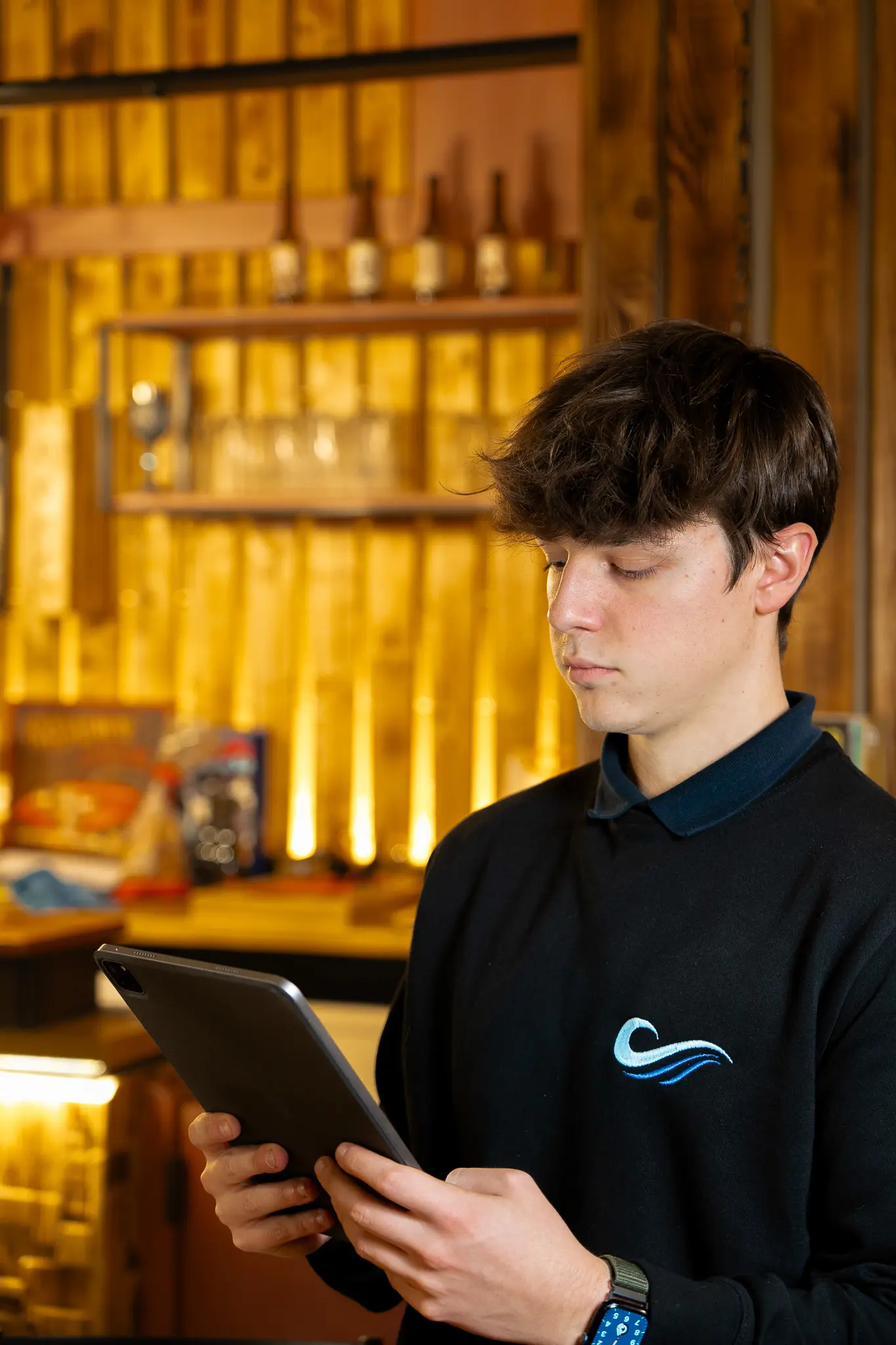Ragazzo del team con la felpa SocialWave che controlla il piano sul tablet